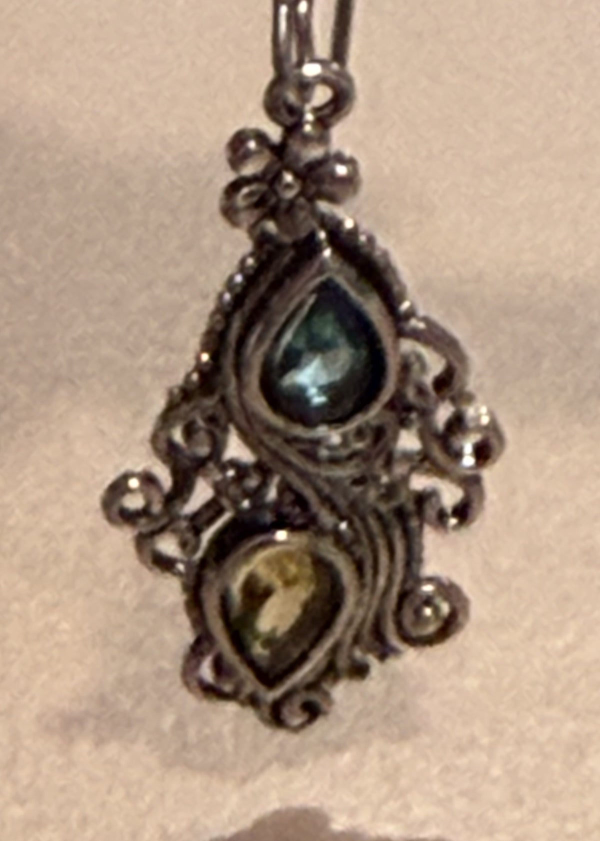 Stella baroque-style silver-toned dangle earrings with blue and green teardrop stones, featuring long interchangeable kidney wires and measuring approximately 2 1/2 inches long.