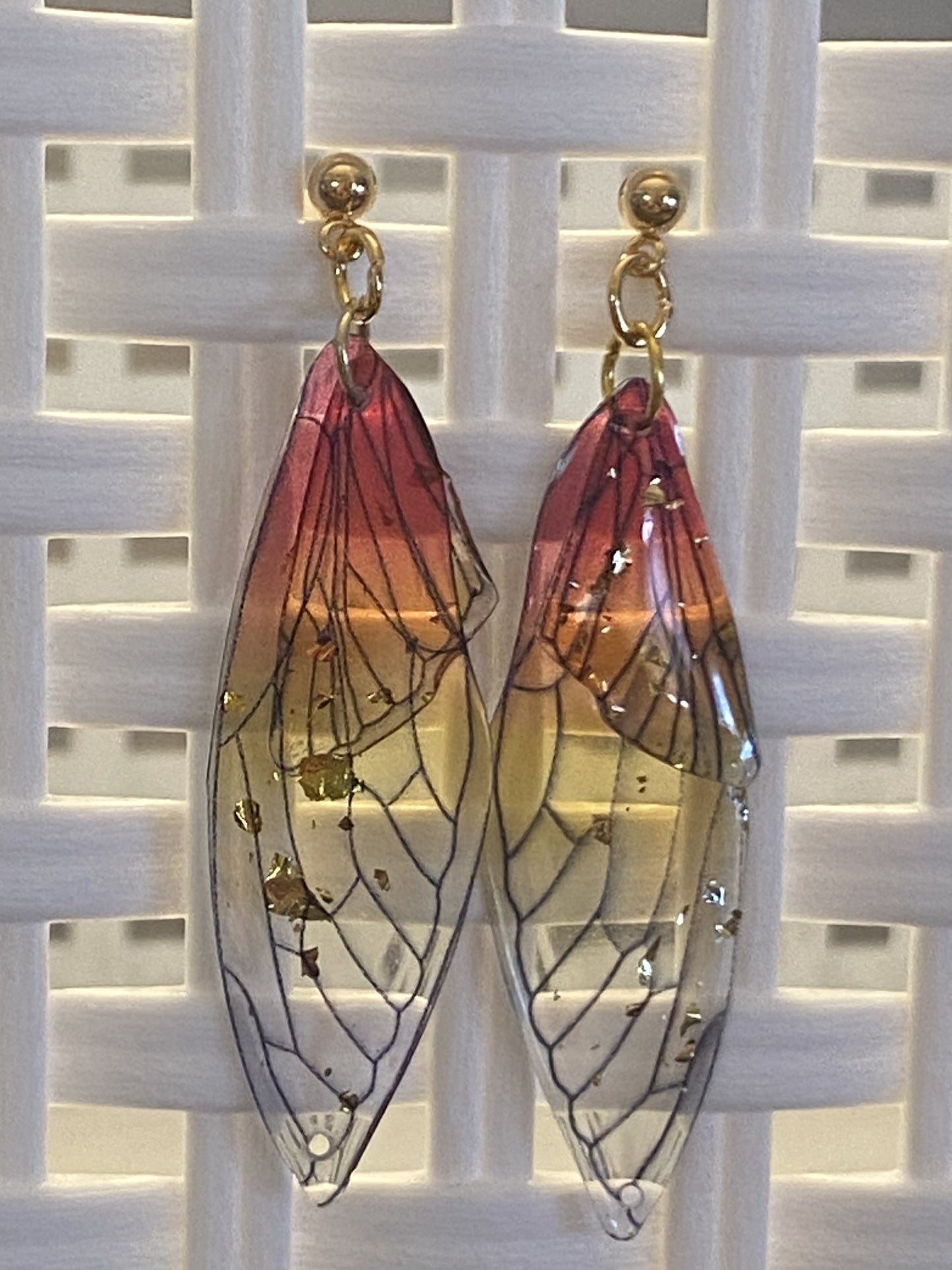 Gold and pink resin butterfly wing earrings with post style and gold-toned base metal.
