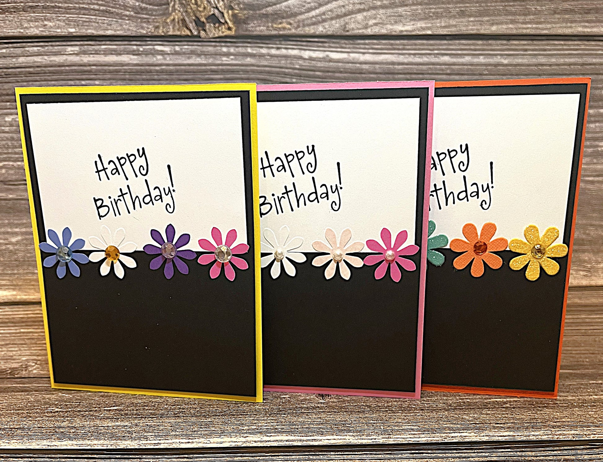 Set of 3 Happy Birthday cards, 4 1/4 x 5 1/2 inches, multicolored base with black accents, paper flowers, and glitter highlights