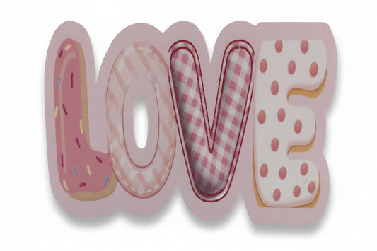 A vinyl sticker spelling LOVE in rounded letters, styled like donuts or pastries with pink and white patterns, shown on a tabletop.