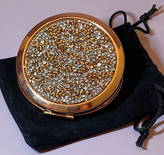 Rose gold compact mirror with clear and bronze crystal accents on front and inscription on back saying Happiness Looks Gorgeous on You, 2 3/4 inch