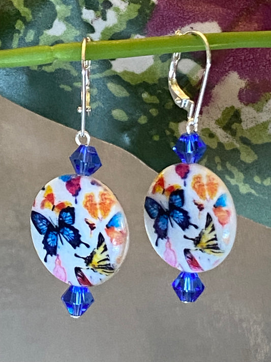 Silver-toned butterfly coin earrings with blue bicone beads and interchangeable lever backs, approximately 1⅞ inches long.
