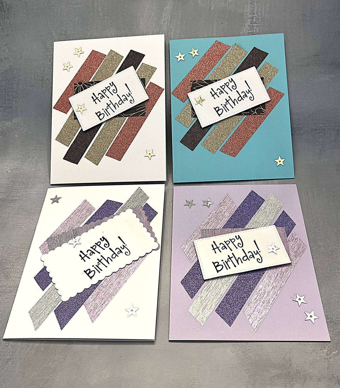 Set of four 4¼" x 5½" Happy Birthday cards decorated with metallic strips and hand-stamped greetings, each paired with a white envelope.