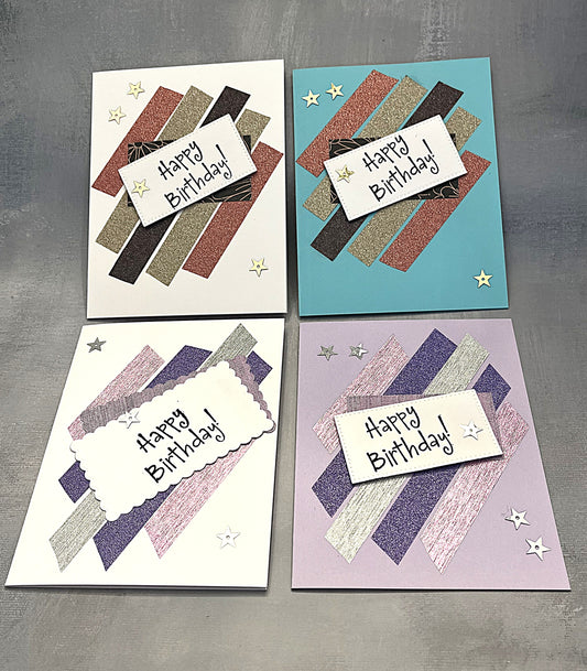 Set of four 4¼" x 5½" Happy Birthday cards decorated with metallic strips and hand-stamped greetings, each paired with a white envelope.