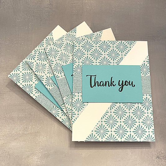 Set of four 4¼" x 5½" Thank You cards with teal geometric shapes and glitter accents, hand-stamped with “Thank You” on the front, paired with envelopes.







