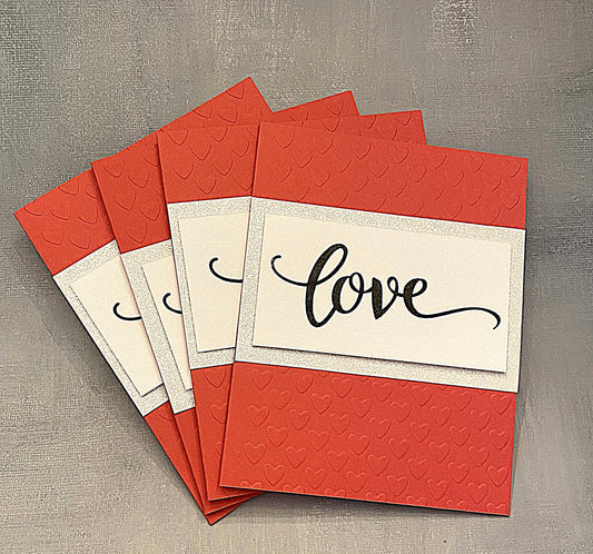 "Set of four handmade red Miss You cards with embossed hearts, glitter accents, and hand-stamped 'Love' on the front, displayed with white envelopes."