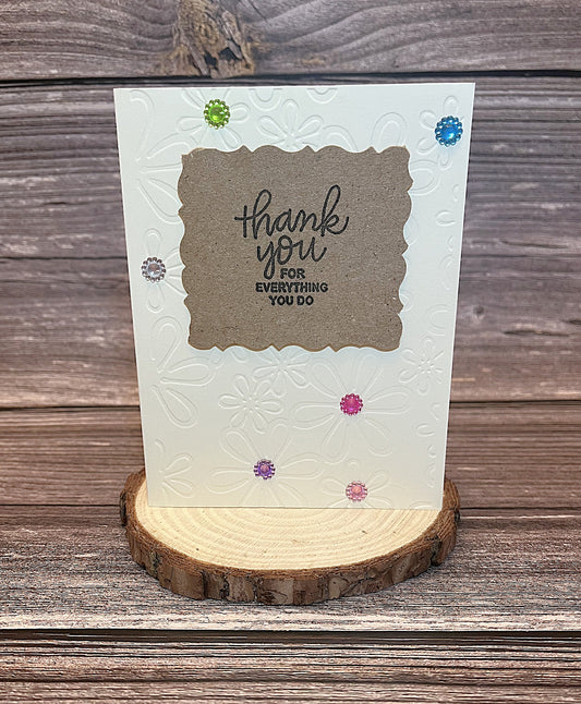 Christian thank you notecard with embossed white floral base, decorative colored gems, and the message “Thank you for everything you do” on the front