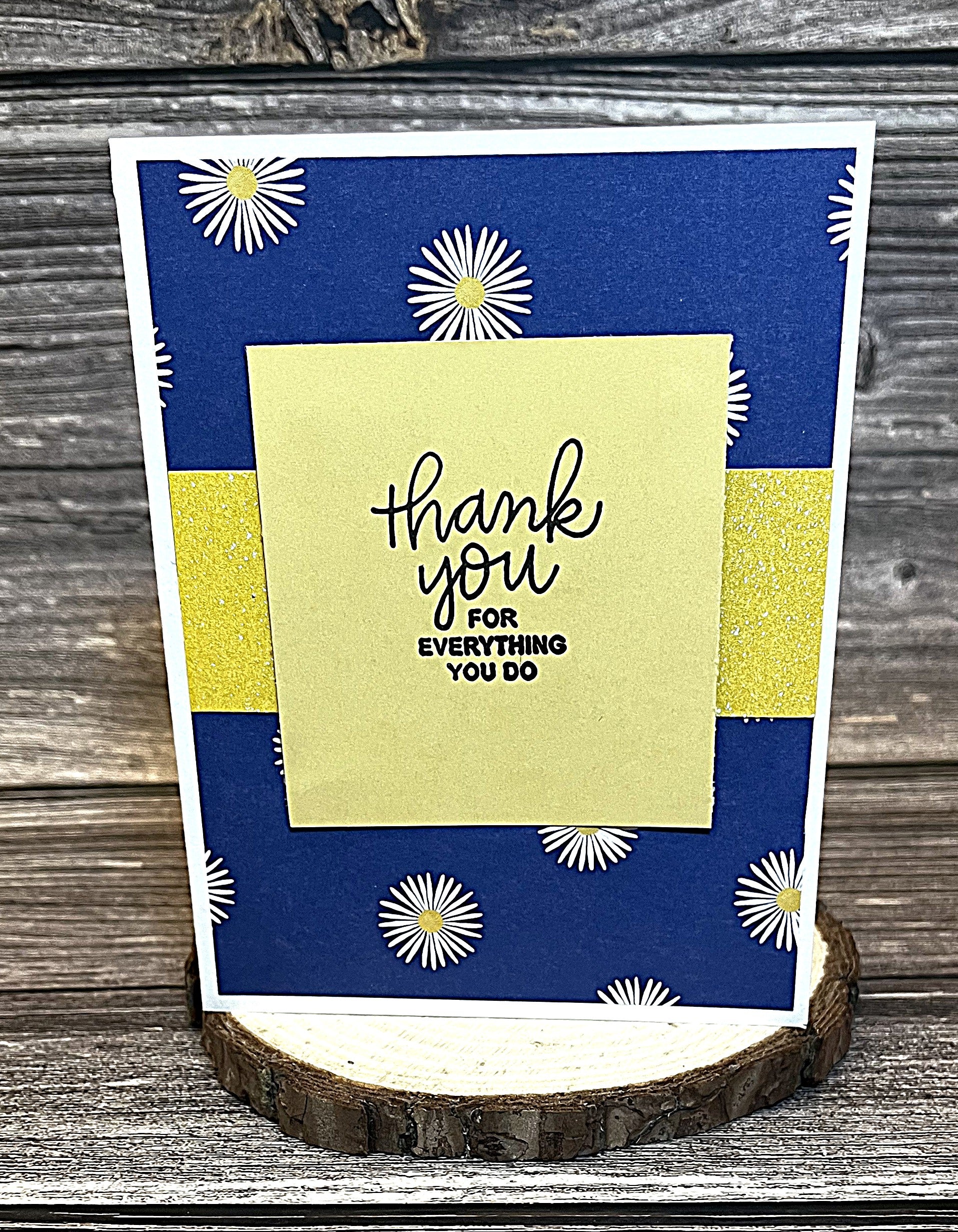 Christian thank you card with white card base, blue decorative paper, white daisies print, and yellow glitter accent