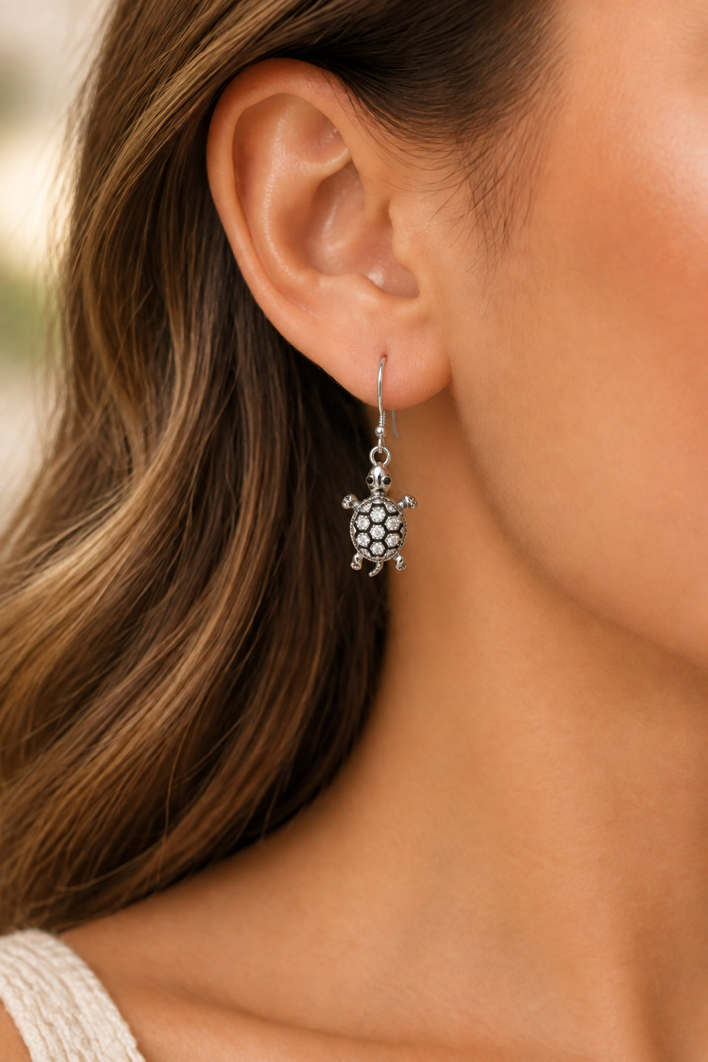 A pair of silver-toned turtle drop earrings embellished with clear rhinestones.