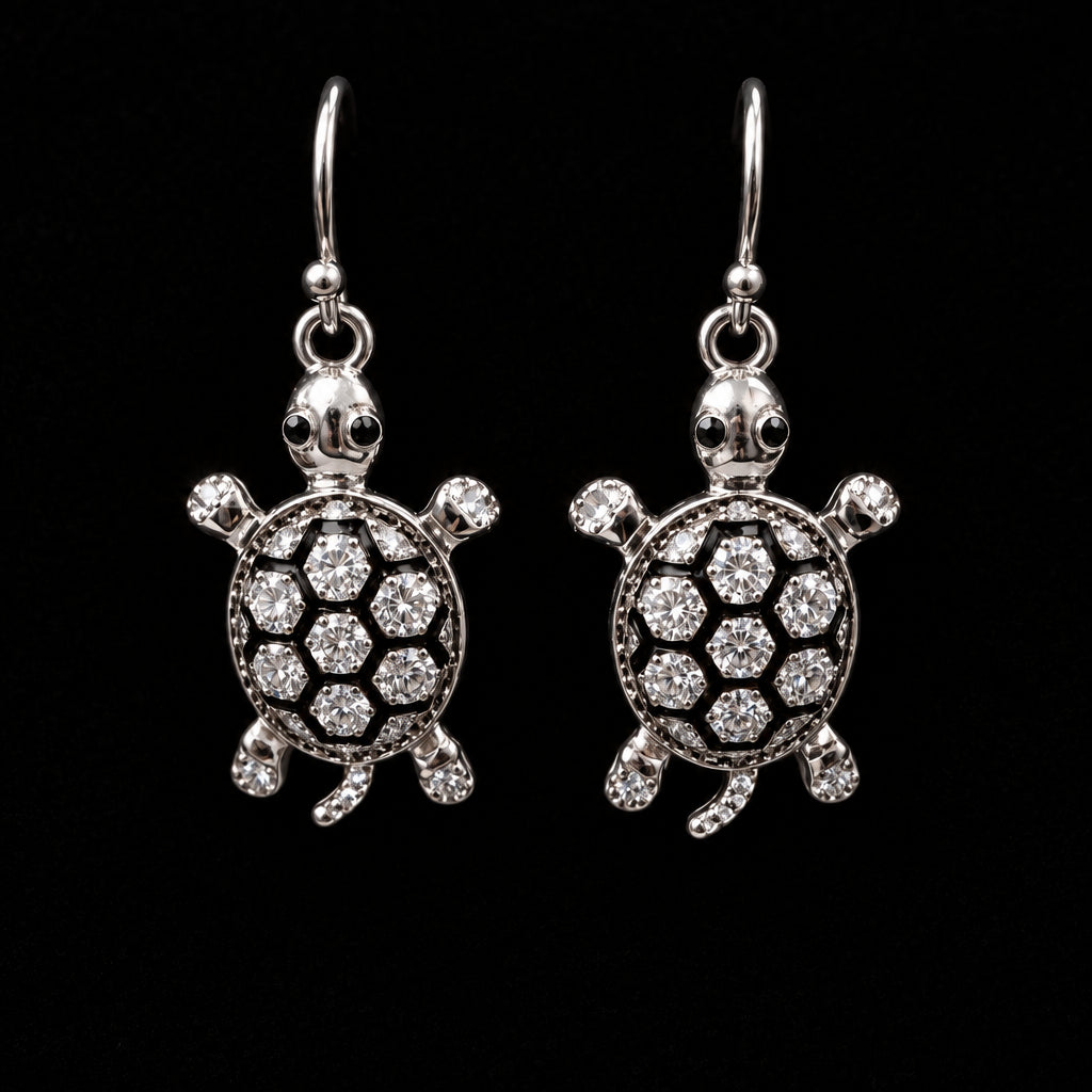 A pair of silver-toned turtle drop earrings embellished with clear rhinestones.